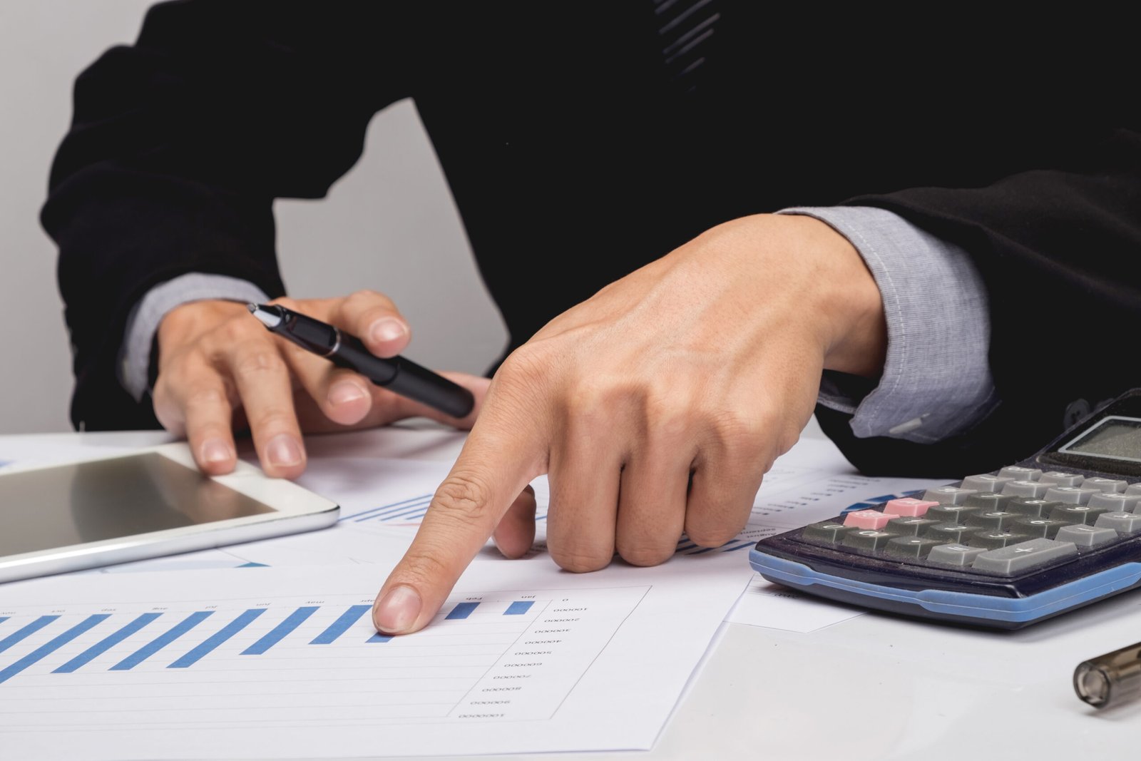Business people discussing financial charts - closeup shot of hands over table.