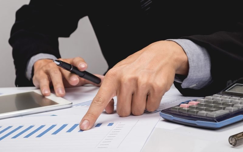 Business people discussing financial charts - closeup shot of hands over table.