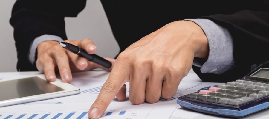 Business people discussing financial charts - closeup shot of hands over table.